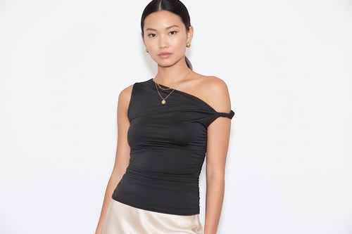 Elevate your wardrobe with this versatile asymmetrical knit top featuring an off-the-shoulder neckline and sleeveless design. The twist shoulder detail and ruched side accents create flattering dimension, while the soft 95% polyester and 5% spandex blend offers comfortable stretch and durability. Perfect for layering or wearing solo, this solid knit top transitions seamlessly from casual to dressed-up occasions.