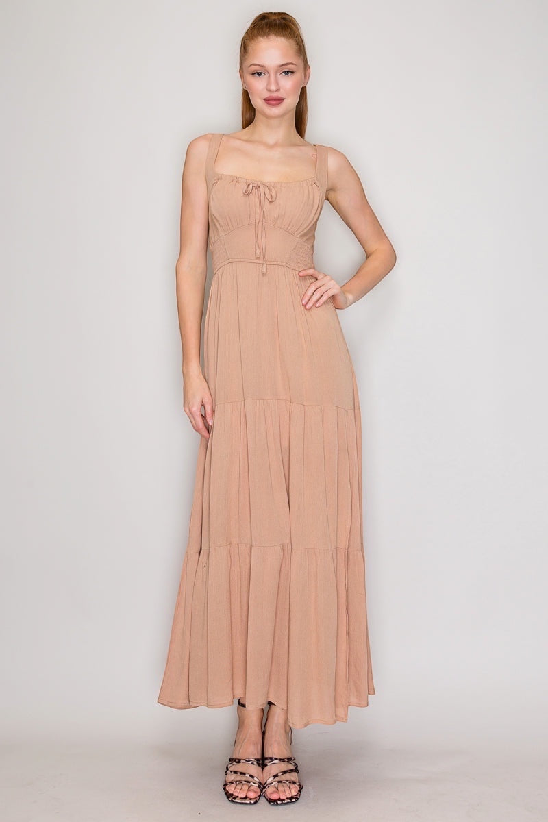 Front Tie High Slit Shirred Maxi Dress.  With a square neckline that says "I have excellent taste" and a sleeveless design that screams "I'm confident," you'll be turning heads at every event. The shirred detail adds just enough texture to keep things interesting, while the lightweight rayon fabric lets you breathe like you actually enjoy being alive. The front-tie detail and high slit?