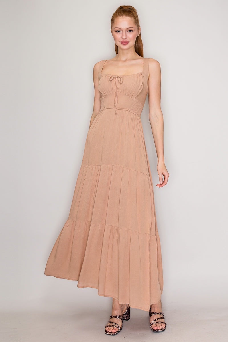 Front Tie High Slit Shirred Maxi Dress.  With a square neckline that says "I have excellent taste" and a sleeveless design that screams "I'm confident," you'll be turning heads at every event. The shirred detail adds just enough texture to keep things interesting, while the lightweight rayon fabric lets you breathe like you actually enjoy being alive. The front-tie detail and high slit?