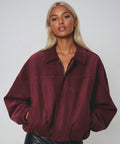 Luxe Life Styled wine faux suede bomber jacket with bat wing sleeves and zip-up front.