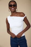Luxe Life Styled white asymmetrical off-the-shoulder knit top with ruched side detail and twist shoulder.